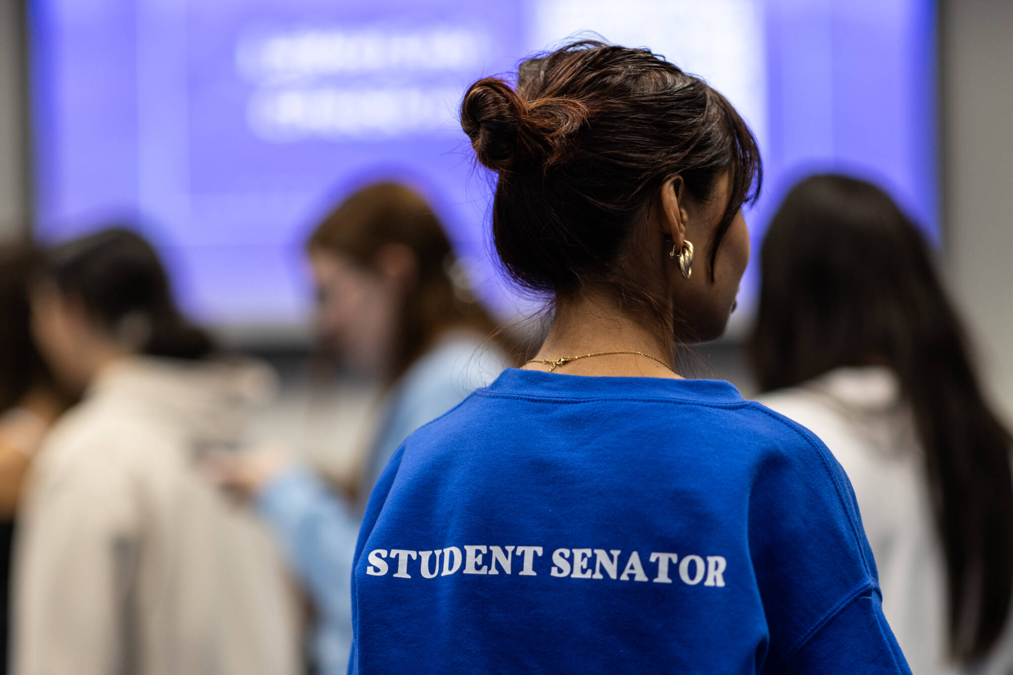 Student Senator turned around with "Student Senator" on the back of her sweatshirt.